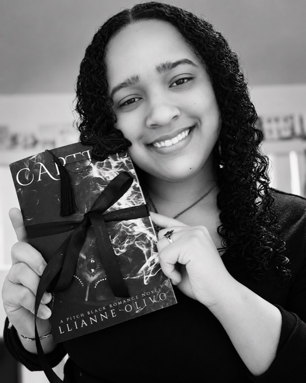 Llianne Olivo holding one of her books